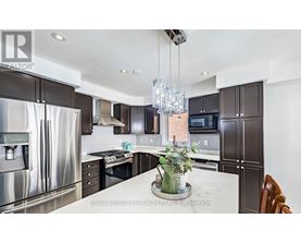 A modern kitchen with a stainless steel refrigerator and dark brown cabinets.