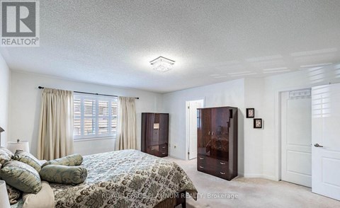 A bedroom with a bed, dresser, and nightstand.