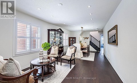 A well-lit living room with a wooden coffee table and a staircase in the background.