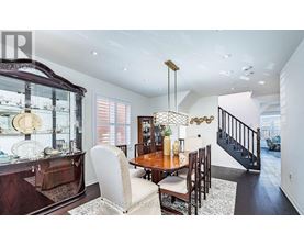 A dining room with a wooden table and chairs.