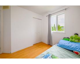 A room with a bed and a window with a view of trees.
