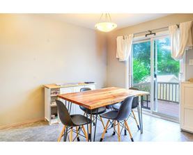 A dining room with a wooden table and chairs.