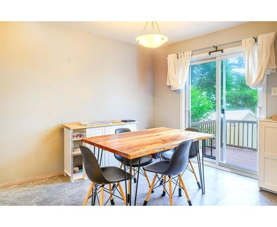 A dining room with a wooden table and chairs.