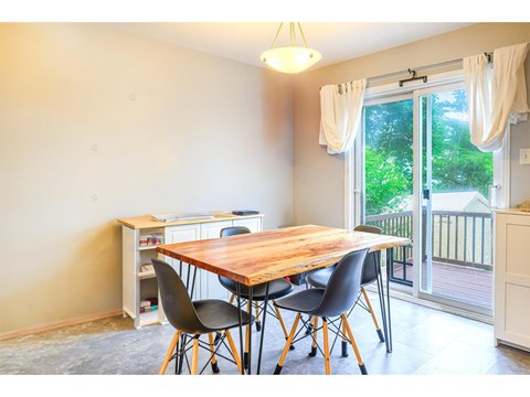 A dining room with a wooden table and chairs.