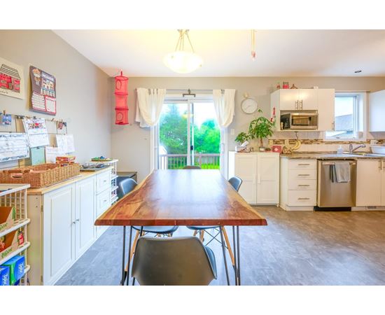 A kitchen with a table and chairs in the middle of the room.