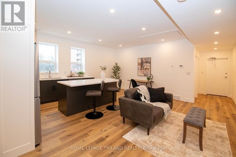 A modern living room with a grey couch and a white dining table.