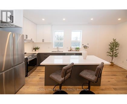 A modern kitchen with a large island and stainless steel appliances.