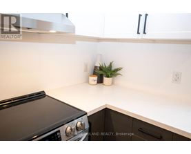 A black oven in a kitchen with white cabinets.