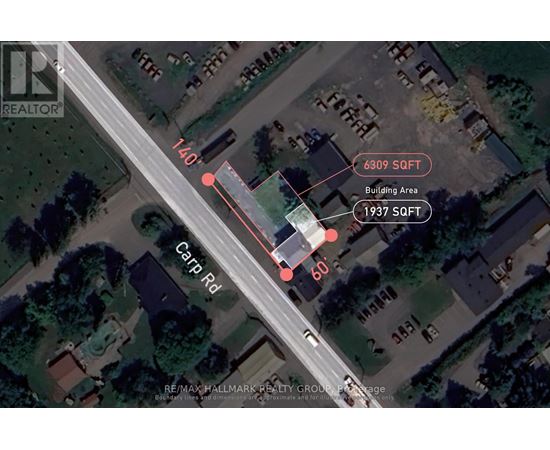 An aerial view of a street with a building and a carport on the right side.