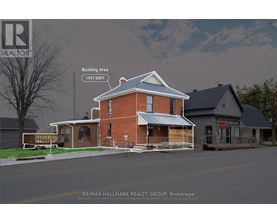A house with a blue roof and a sign that says RE/MAX Hallmark Realty Group.