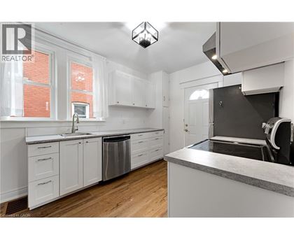 A kitchen with white cabinets and a grey counter top.