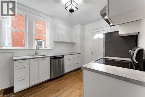 A kitchen with white cabinets and a grey counter top.