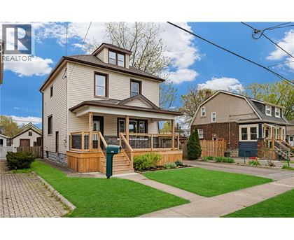 A house with a well-maintained lawn and a clear sky in the background.