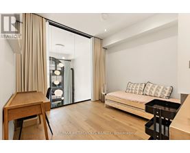 A bedroom with a bed, desk, and chair.