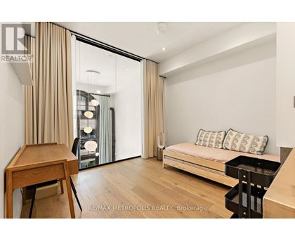 A bedroom with a bed, desk, and chair.