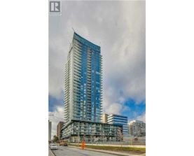 A tall blue building under construction with a cloudy sky in the background.