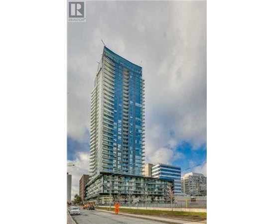 A tall blue building under construction with a cloudy sky in the background.