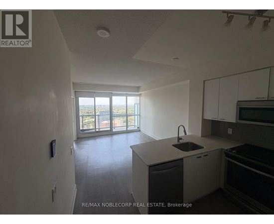 A kitchen with a sink and a window overlooking a balcony.
