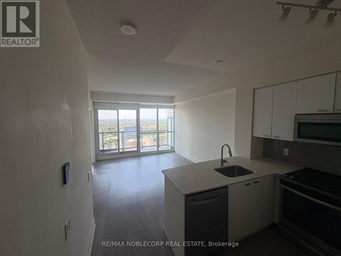 A kitchen with a sink and a window overlooking a balcony.