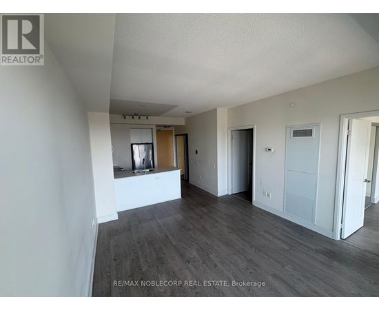 A spacious room with wooden flooring and white walls, ready for a new tenant.
