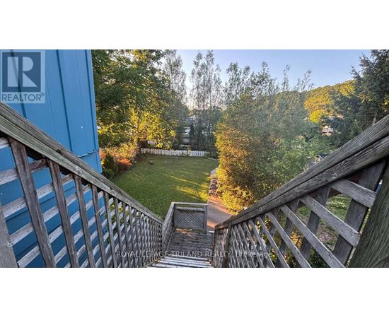 A wooden staircase leads down to a grassy area.