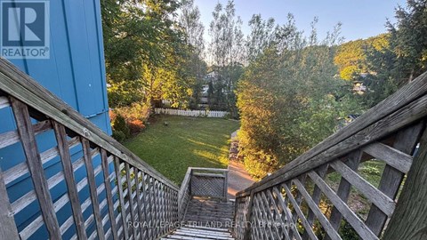 A wooden staircase leads down to a grassy area.