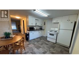 A kitchen with white appliances and a wooden table.