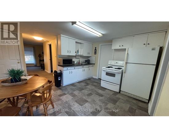 A kitchen with white appliances and a wooden table.