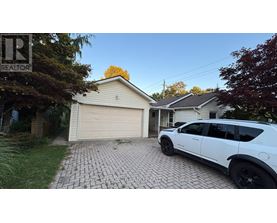 A white SUV is parked in front of a garage.