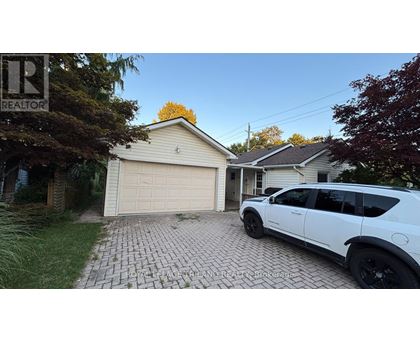 A white SUV is parked in front of a garage.