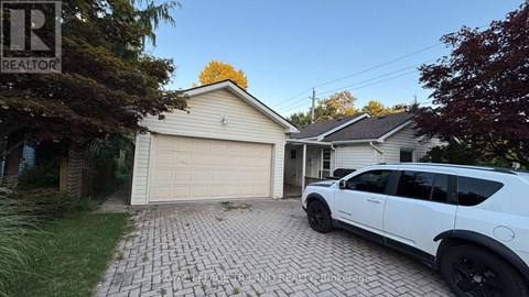 A white SUV is parked in front of a garage.
