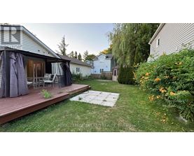 A backyard with a deck and patio furniture.