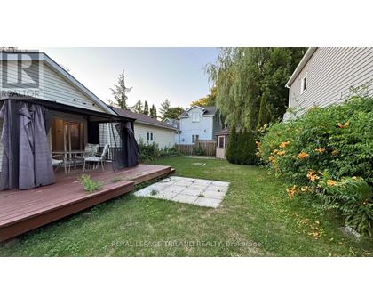 A backyard with a deck and patio furniture.