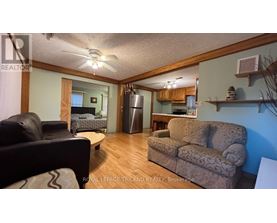 A living room with a couch, chair, and a fan.