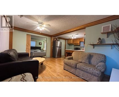 A living room with a couch, chair, and a fan.