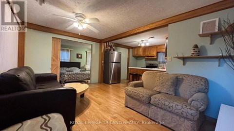A living room with a couch, chair, and a fan.
