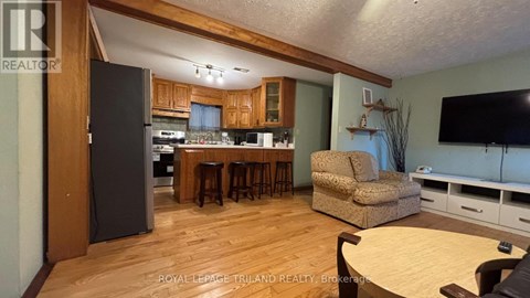 A kitchen with a refrigerator, microwave, and oven.