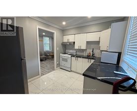 A modern kitchen with white cabinets and a black countertop.