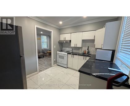 A modern kitchen with white cabinets and a black countertop.