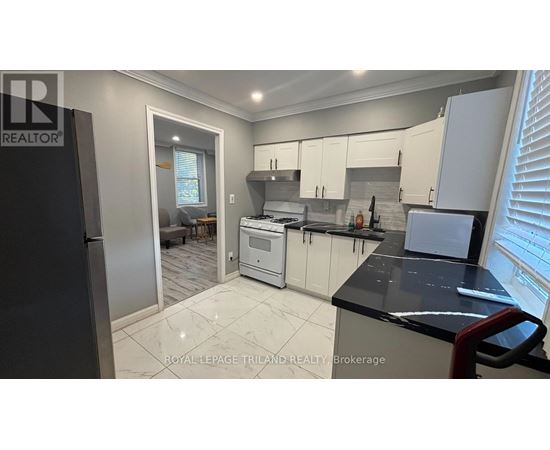 A modern kitchen with white cabinets and a black countertop.