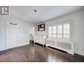A bedroom with a bed, dresser, and window.