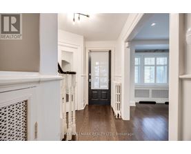 A spacious hallway with a black door and white walls.