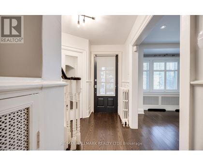 A spacious hallway with a black door and white walls.