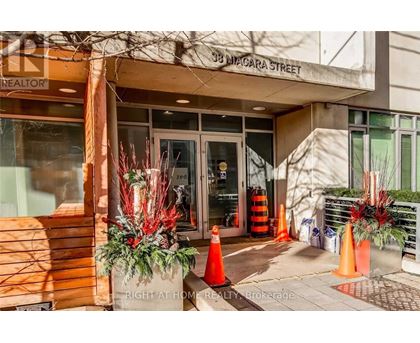 The entrance to a realtor's office is decorated with red and green plants.
