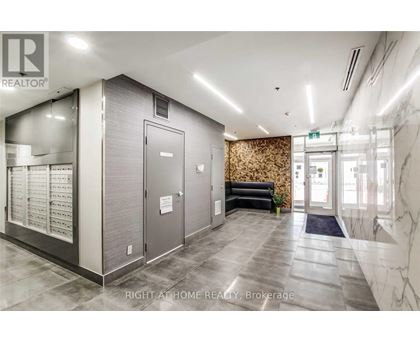 A hallway with a marble floor and a wall with a floral pattern.