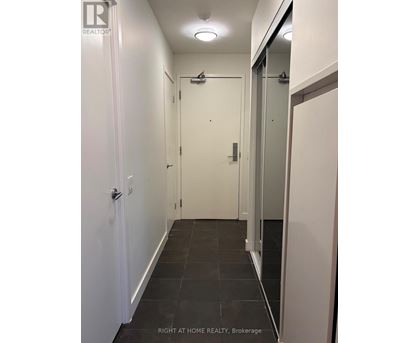A hallway with a door on the left and a glass door on the right.