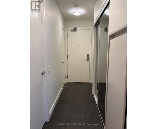 A hallway with a door on the left and a glass door on the right.