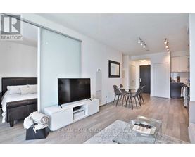 A modern bedroom with a large bed and a flat screen TV.