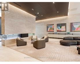 A modern waiting room with a large stone wall and comfortable seating.