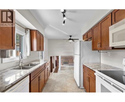 A kitchen with brown cabinets and a white refrigerator.